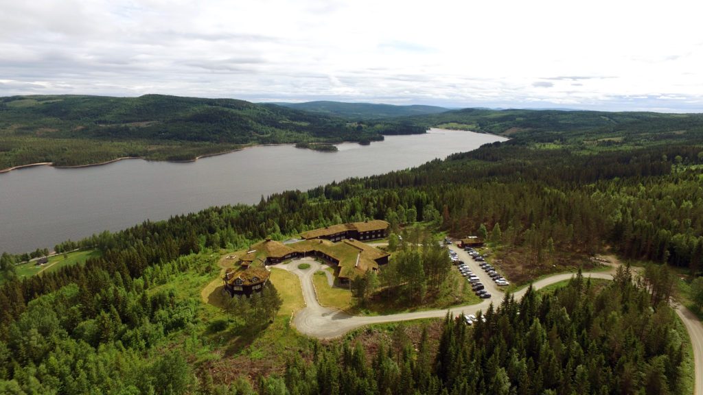 oversiktsbilde av Finnskogtoppen Spa og Velværehotell fra fugleperspektiv med innsjøen Røgden i bakgrunnen.