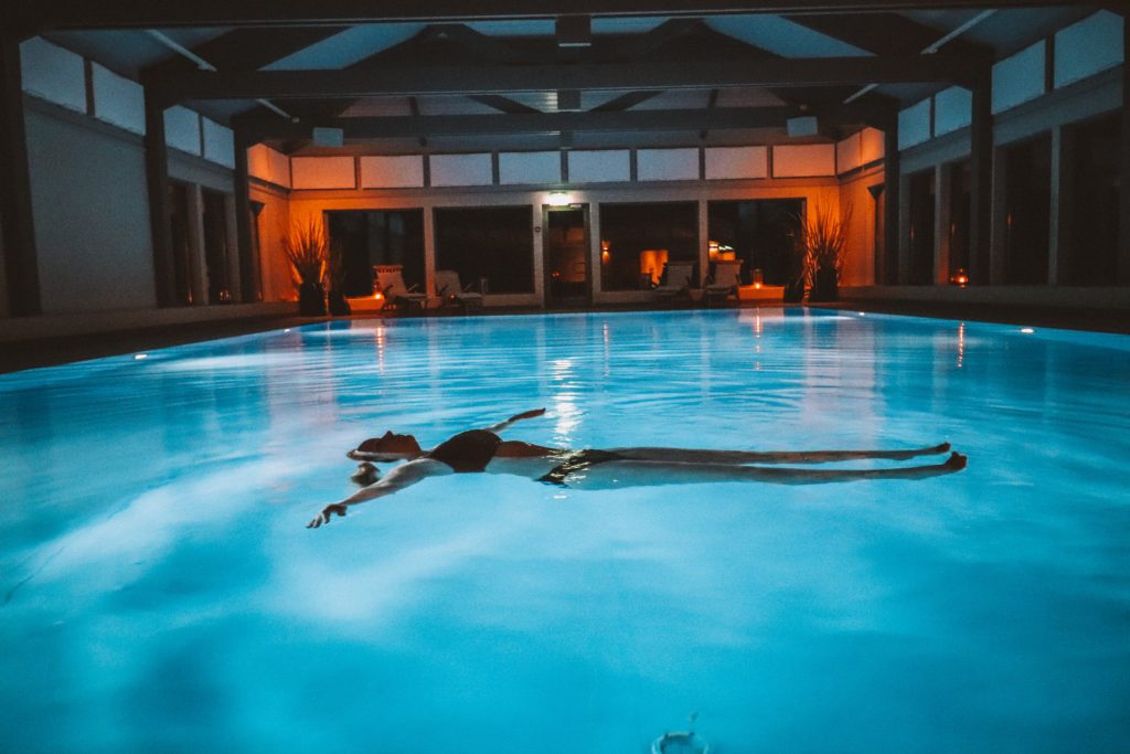 bildet viser bassengområdet. kvinne flyter avslappet i bassenget.